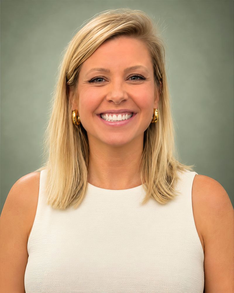 Sarah Ferrara, smiling, in an ivory top against a sage green background